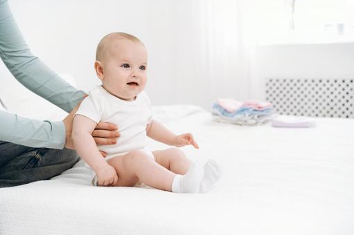 Smiling baby sitting with support under his arm, JPG Smiling baby sitting with support under his arm, JPG
