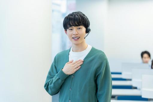 インカムで話すオペレーターの若い男性 オペレーター,コールセンター,笑顔の写真素材