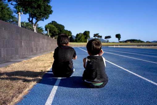<素材>陸上競技の練習中に休憩する兄弟 <素材>陸上競技の練習中に休憩する兄弟 子供,兄弟,ジョギングの写真素材