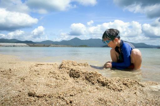 <素材>夏の海で楽しく砂遊びをする男の子 <素材>夏の海で楽しく砂遊びをする男の子 子供,男性,人物の写真素材