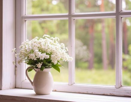 窓辺の花瓶に入った白い花 窓辺の花瓶に入った白い花の写真