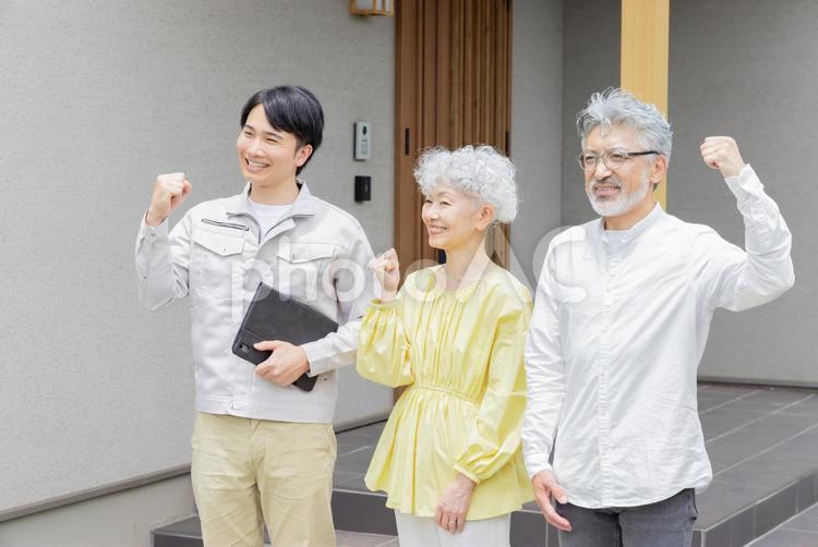 住宅の前で笑う男性作業員とシニア夫婦 平屋建て,屋外,シニアの写真素材