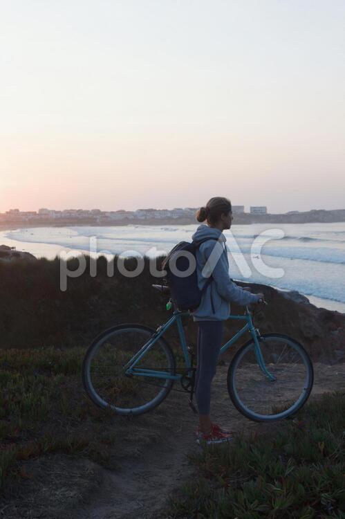海辺で自転車と佇む女性 サイクリング,女性,自転車の写真素材