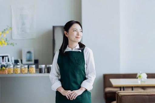 カフェで働く若い女性 カフェで働く若い女性の写真