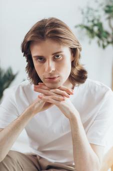 両手を組んで椅子に座っているカメラ目線の男性 男性,外国人,欧米人の写真素材