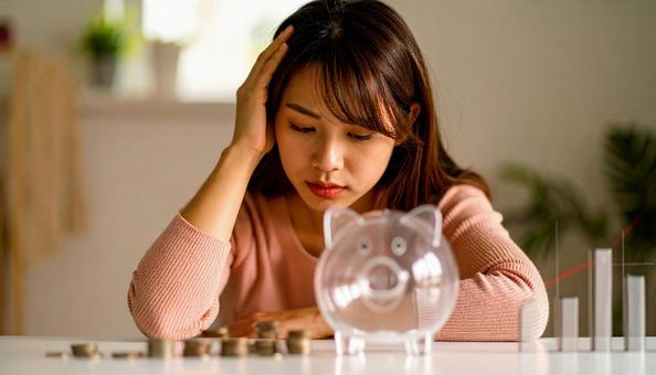 投資か貯金、どちらがいいか悩む若い女性の写真