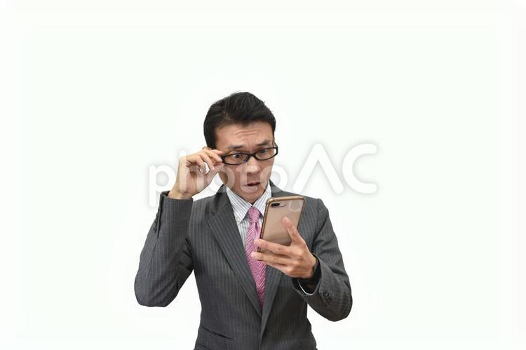 スマホを見て驚くメガネのビジネスマン ビジネス,ビジネスマン,男性の写真素材
