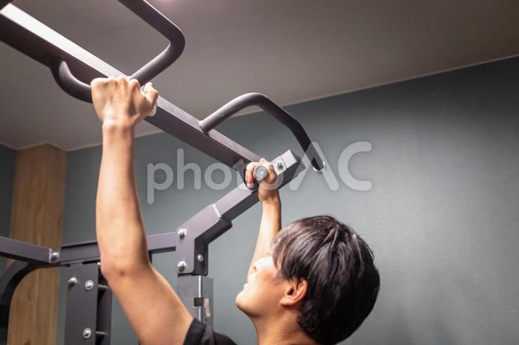 スポーツジムで鍛える男性（懸垂） 懸垂,アシストチンニング,ワークアウトの写真素材