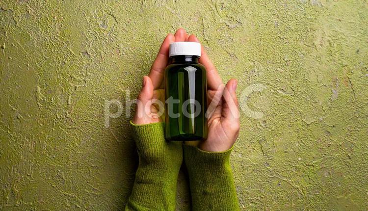 薬の入ったガラスの薬瓶を持つ女性の手 薬,手,女性の写真素材