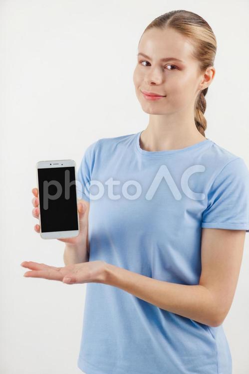 カメラ目線でスマホを持つ女性 女性,スマートフォン,画面の写真素材