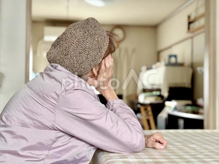 台所のテーブルで頬杖をつく高齢女性 高齢者,女性,人の写真素材