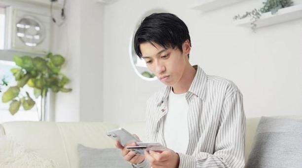 マイナ保険証を設定するアジア人男性 男性,マイナ保険証,マイナンバーカードの写真素材