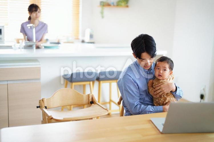 抱っこして子供をあやす父 男の子,抱っこ,ノートパソコンの写真素材