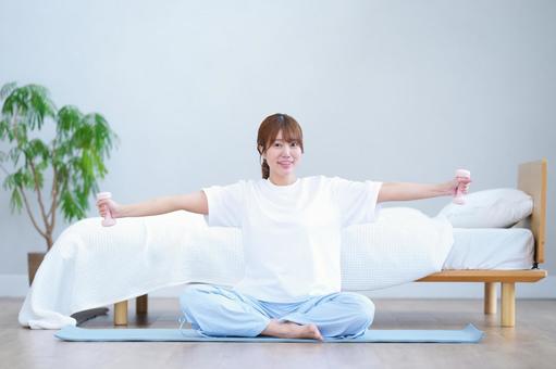 ダンベルを持ち手を横に伸ばし筋トレする女性 女性,ダンベル,持つの写真素材