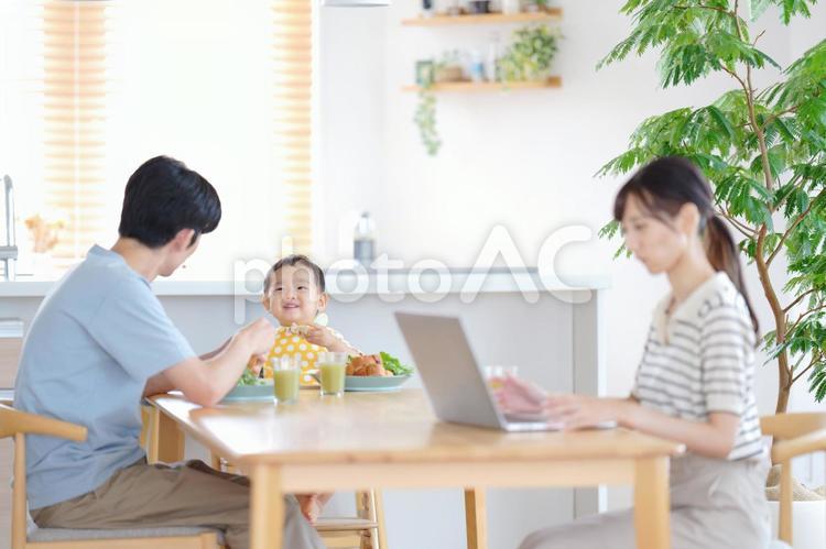 楽しそうに食事をする子供とパソコンをする母 親子,女性,ノートパソコンの写真素材