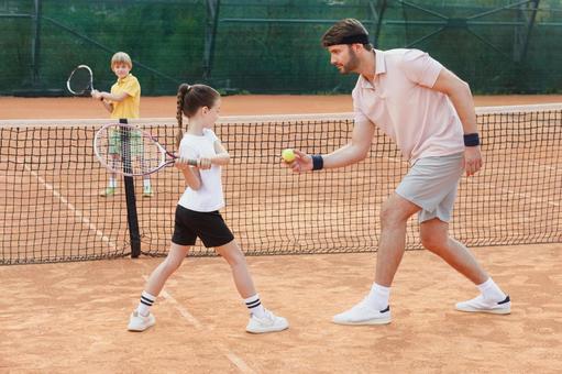 ラケットを持つ女の子とサポートする男性 子供,テニス,指導の写真素材