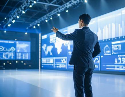 ステージ上で堂々とプレゼンする男性 ステージ上で堂々とプレゼンする男性の写真