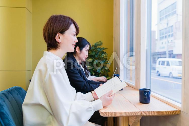 カフェの窓際カウンター席にいる女性（読書） 本,読書,勉強の写真素材