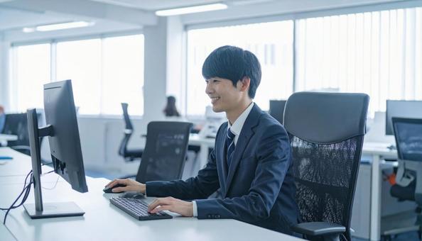 PC作業をするビジネスマン PC作業をするビジネスマンの写真