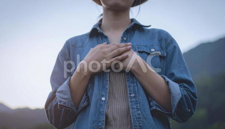真心のイメージ　胸の前で手をあわせる女性 真心,手元,シャツの写真素材