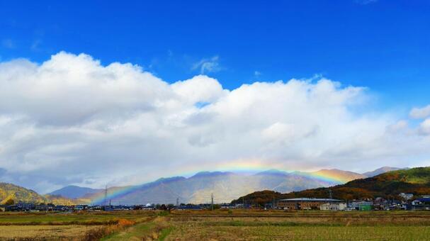 紅葉の山と街に虹がかかる幻想的な風景 虹,レインボー,街の写真素材