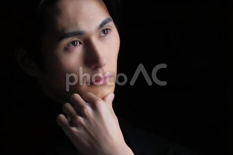 顎の下に手を置いて考える男性（黒） 男性,クール,美容男子の写真素材