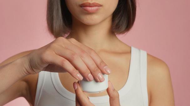 クリームのジャーの蓋を開けようとしている女性 クリームのジャーの蓋を開けようとしている女性 女性,外国人,アジア人の写真素材