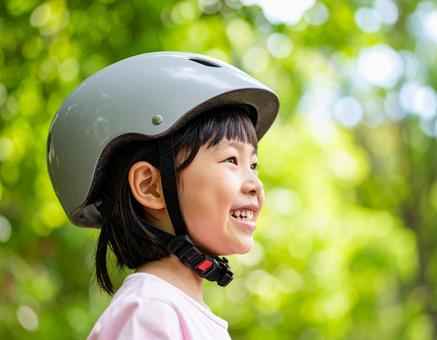 自転車用ヘルメットをかぶる女の子 自転車用ヘルメットをかぶる女の子の写真