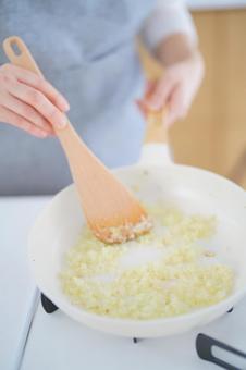 フライパンで玉ネギを痛めている人の写真