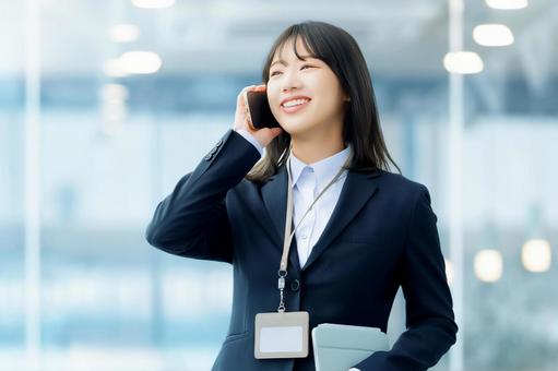 スマホで話す笑顔の女性・ビジネスウーマン 女性,スマホ,スマートフォンの写真素材