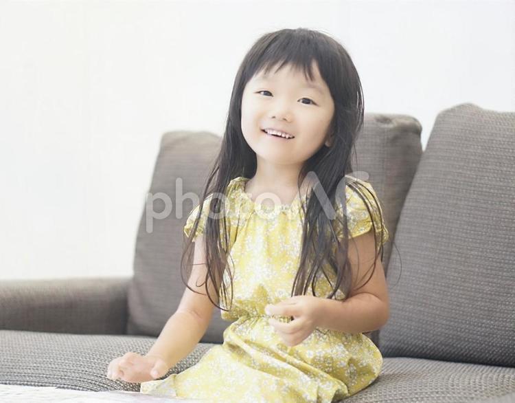 ソファーに座った笑顔の女の子 笑顔,子供,女の子の写真素材