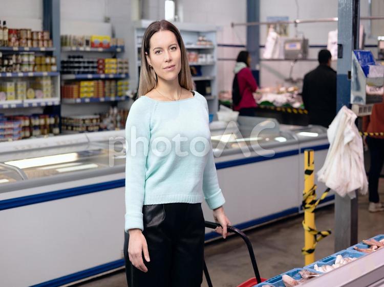 カートを引いてカメラ目線の女性（冷蔵庫） 女性,買い物,観光客の写真素材