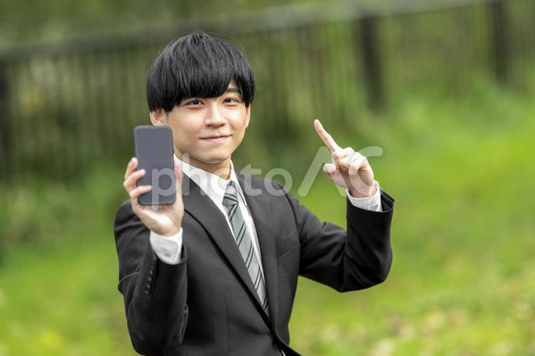 屋外でスマホを使うビジネスマン 就職,キャリア,若いの写真素材