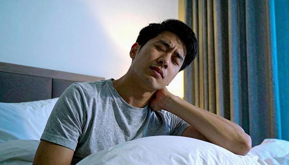 寝違えて首痛に苦しむ男性の写真