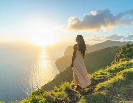 夕日を眺める女性 海と断崖 夕日を眺める女性 海と断崖の写真