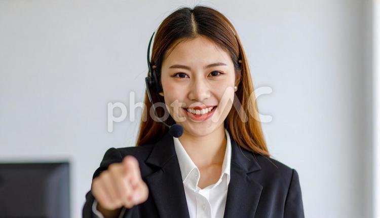 ヘッドセットをつけカメラ目線で笑顔の女性 サポートセンター,オペレーター,ビジネスウーマンの写真素材