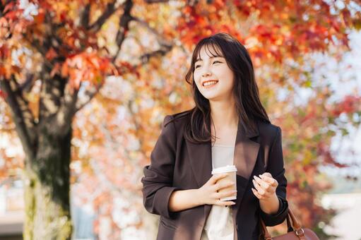 紅葉の並木道を歩く女性 女性,紅葉,秋の写真素材