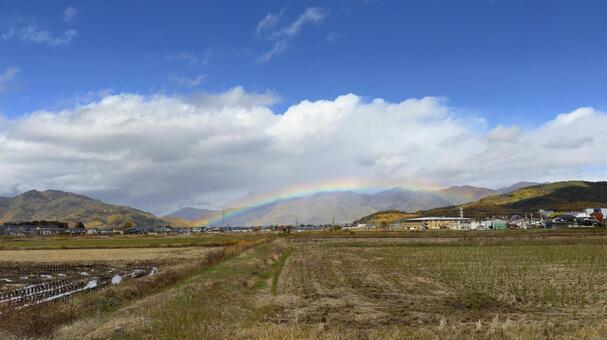 紅葉の山と街に虹がかかる幻想的な風景 虹,レインボー,街の写真素材