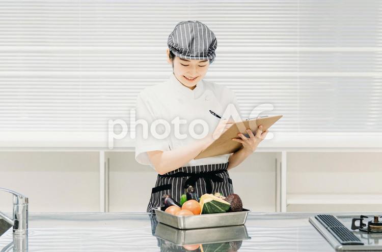 食品をチェックする女性（栄養士・調理師） 栄養士,調理師,管理栄養士の写真素材
