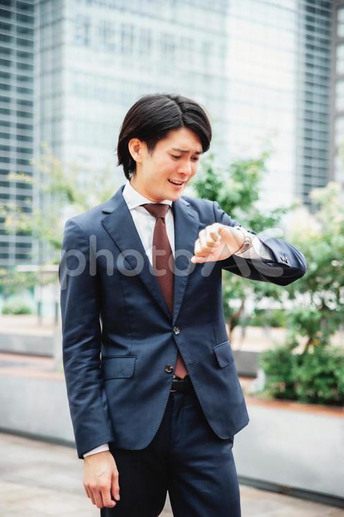 時計を見て焦るビジネスマン（遅刻） 遅刻,忙しい,締め切りの写真素材