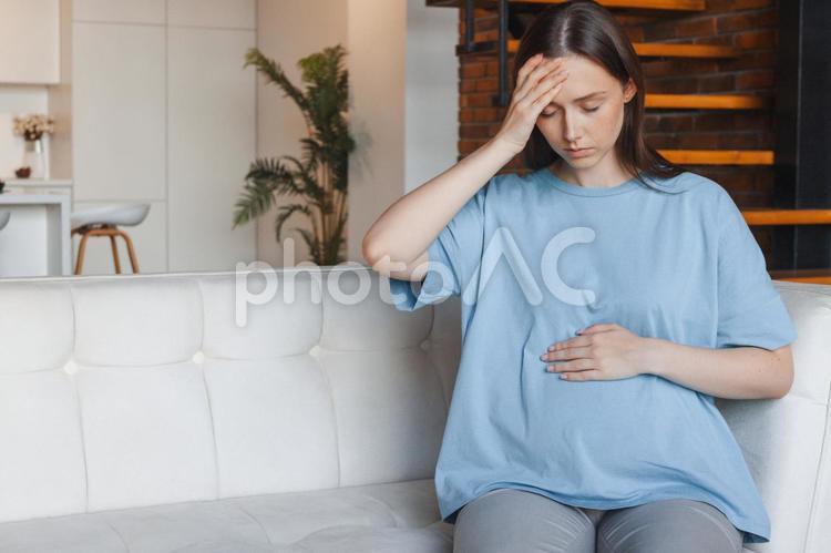 頭をおさえて座る女性 女性,人物,妊婦の写真素材