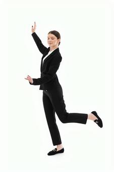 片足を上げポーズするスーツ女性 片足を上げポーズするスーツ女性の写真