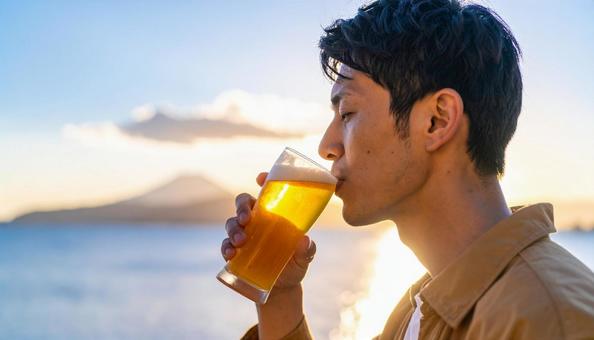 ビールを飲む若い男性のポートレート ビールを飲む若い男性のポートレートの写真