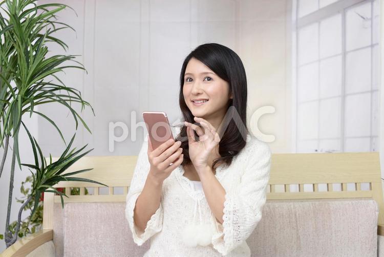 スマートフォンを持つ笑顔の女性 女性,スマートフォン,女の写真素材