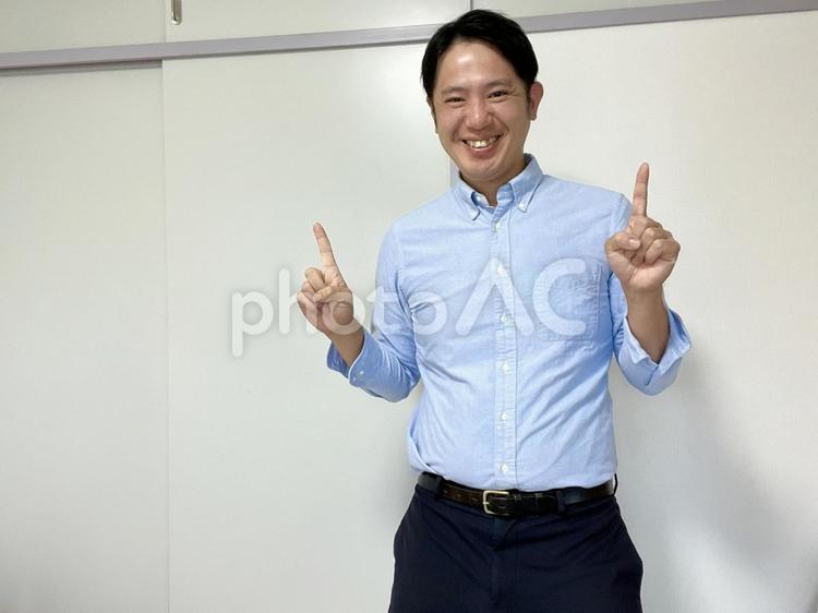 上を指差しご機嫌な男性　2 笑顔,男性,指差しの写真素材