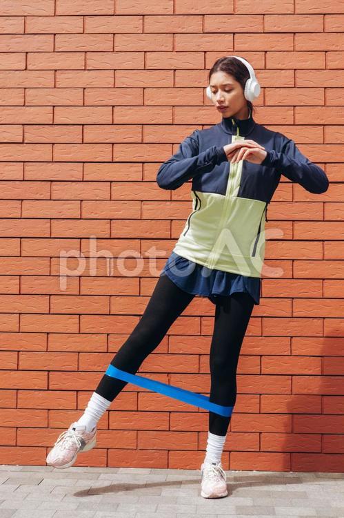 青のタスキを足につけて踊っている女性 女性,青,ヘッドフォンの写真素材