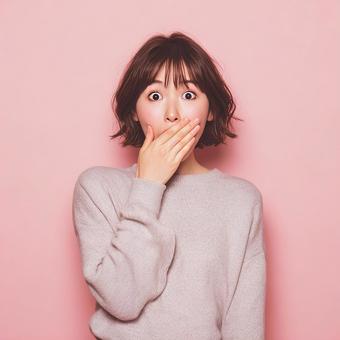 口に手を当てて驚きを隠せない女性 口に手を当てて驚きを隠せない女性の写真