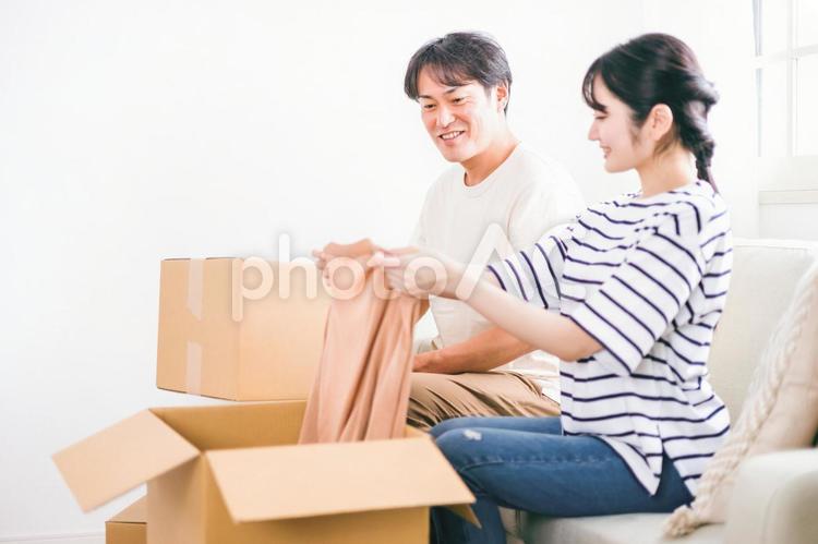 引越し作業で段ボールに荷物を詰める夫婦 引越し,荷物,夫婦の写真素材