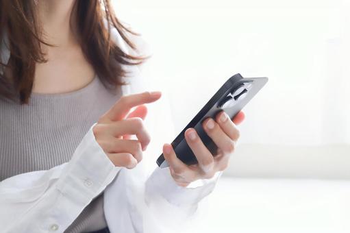 スマートフォンを使う女性 スマートフォンを使う女性の写真