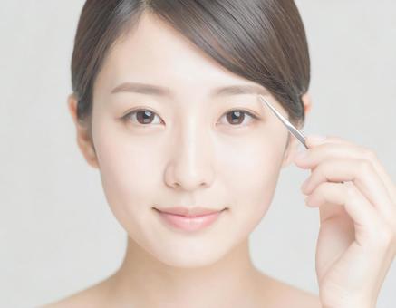 眉を整える女性 眉を整える女性の写真